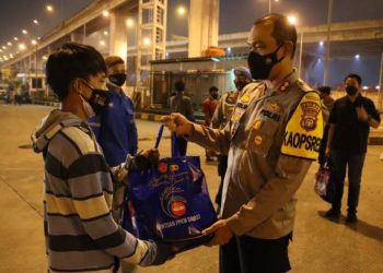 Sambil Bagikan Sembako, Polisi Tertibkan Warga yang Masih Bekerja di Malam Hari dengan Santuy