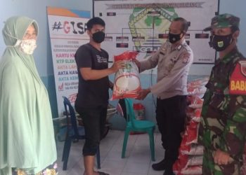 Bhabinkamtibmas Barombong Awasi Penyaluran Bansos Beras PPKM warga terdampak Covid-19